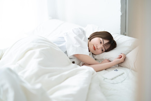 Frau schläft auf einem Bett in einem hellen Raum