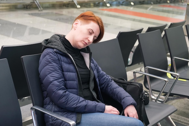 Frau schläft im Abflugbereich eines internationalen Flughafens