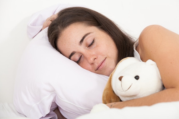 Frau schläft mit einem Teddybär