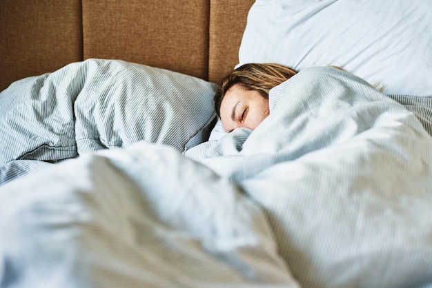 Frau schläft morgens im Bett