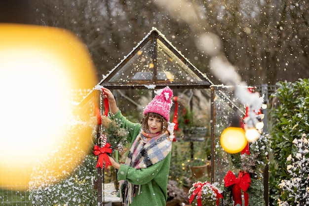 Frau schmückt Gewächshaus für Winterferien