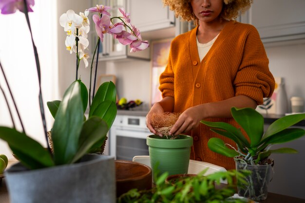 Foto frau schmückt ihr zuhause mit orchideen