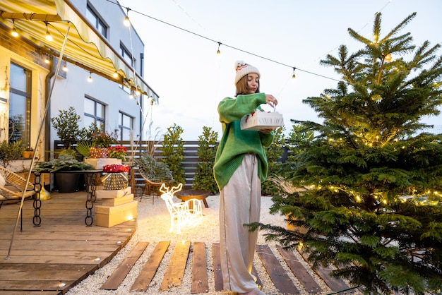 Frau schmückt Weihnachtsbaum im Hinterhof