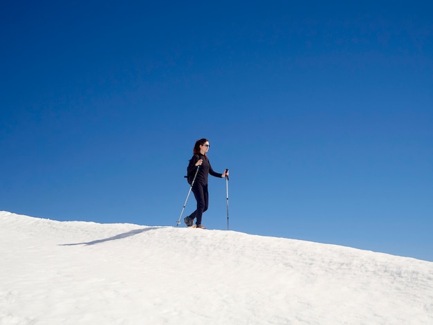 Frau Schneeschuhwandern in San Isidro, León, Spanien an einem sonnigen Tag