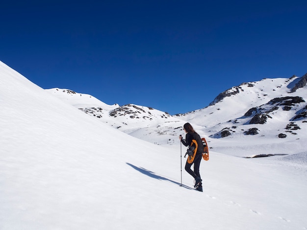 Frau Schneeschuhwandern in San Isidro, León, Spanien an einem sonnigen Tag