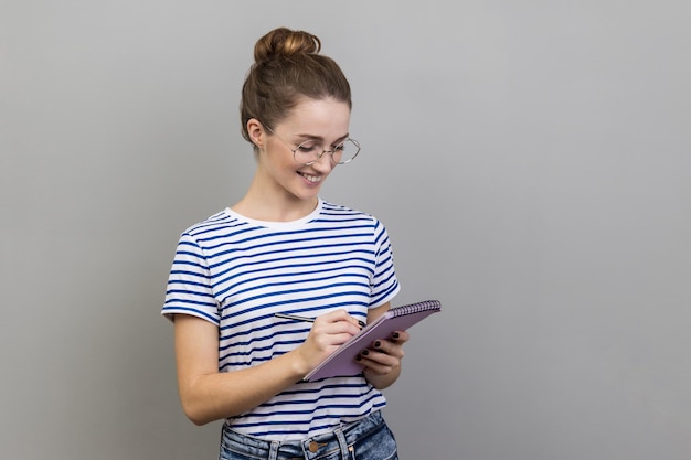 Frau schreibt interessante Idee in Notizbuch auf und macht Pläne Todo-Liste