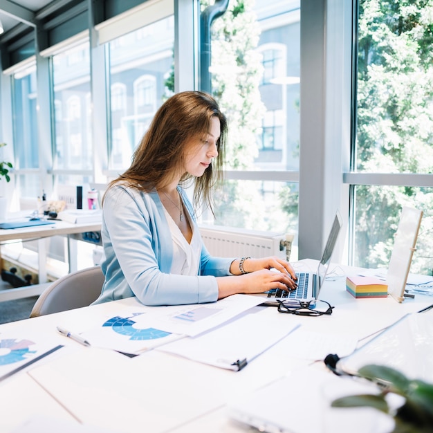 Foto frau schreibt laptop im büro