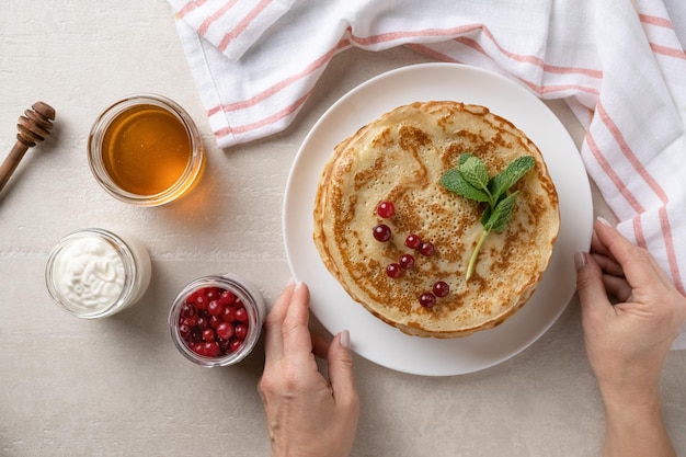 Frau serviert dünne Pfannkuchen auf dem Esstisch für die Draufsicht des Faschingsdienstags