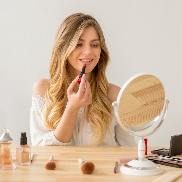 Foto frau setzt lippenstift auf