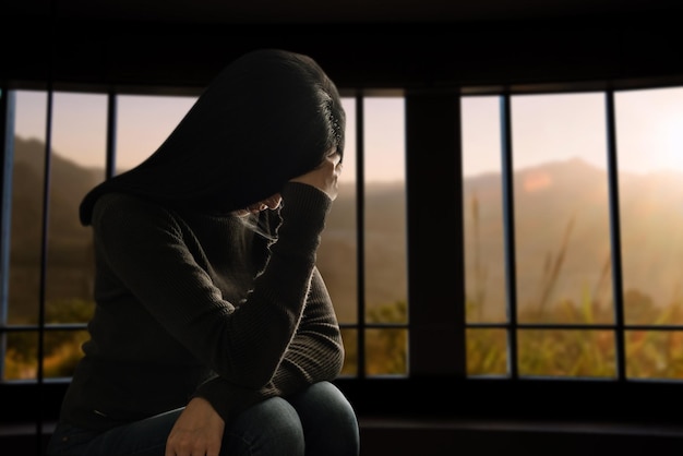 Frau sitzen Depression Stehen am Fenster und Angst Textfreiraum xA