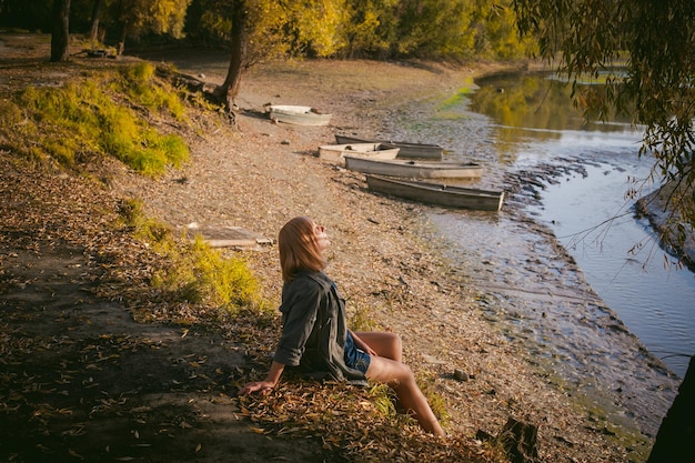 Frau sitzt am See