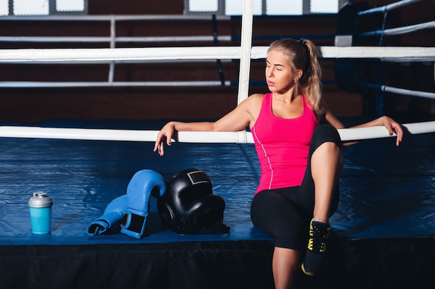 Frau sitzt auf dem Boxring