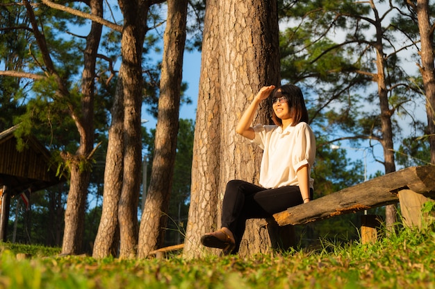 Frau sitzt auf einem Holz