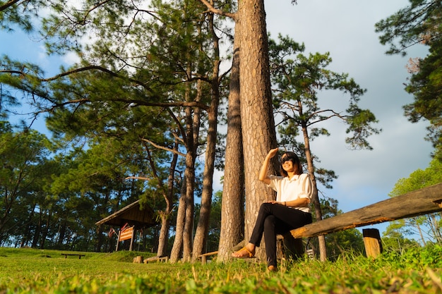 Foto frau sitzt auf einem holz