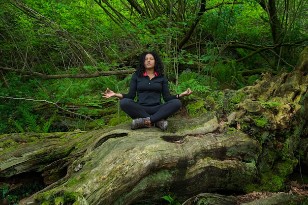 Frau sitzt auf Log in Yoga-Pose