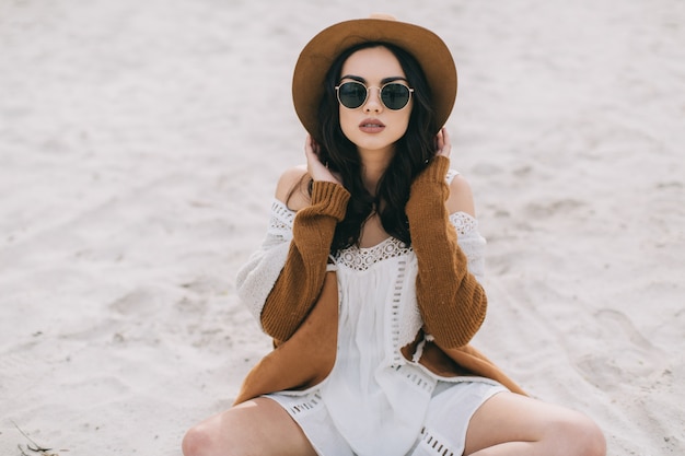 Frau sitzt auf Sand