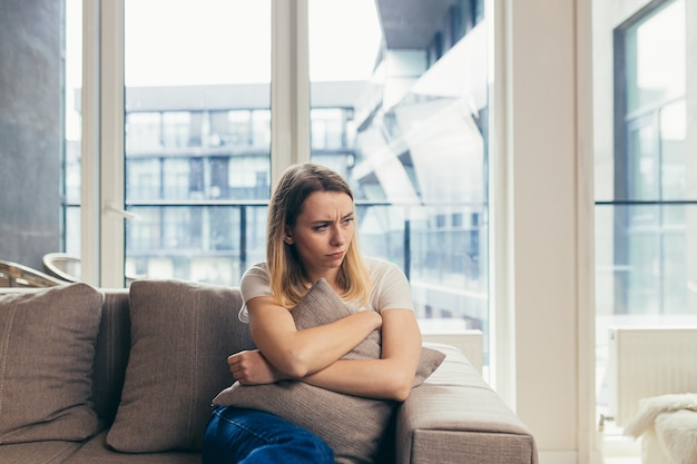 Frau sitzt depressiv auf dem Sofa zu Hause