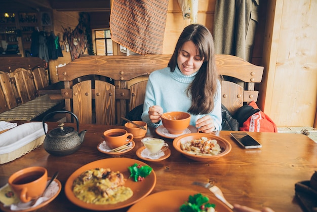 Frau sitzt im Café und isst Aufwärmsuppe. Lebensstil