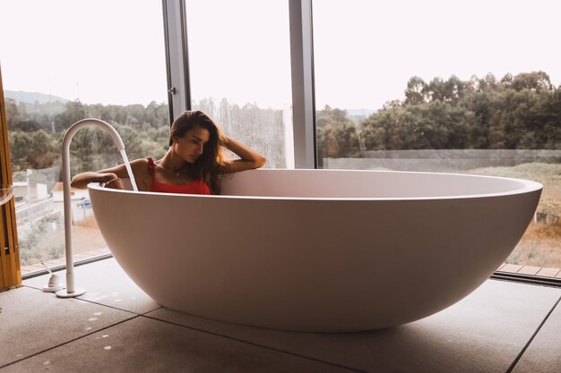 Foto frau sitzt in der badewanne im badezimmer