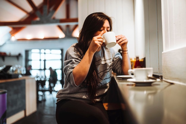 Frau sitzt in einem Café und trinkt Kaffee