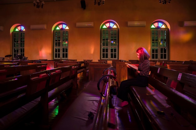 Foto frau sitzt und betet beim lesen aus der bibel in der kirche. religionskonzept