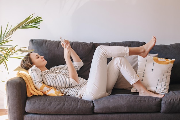 Frau sitzt zu Hause auf dem Sofa