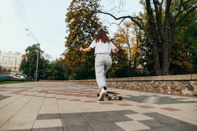 Frau Skater geht auf einem Longboard durch die Stadt