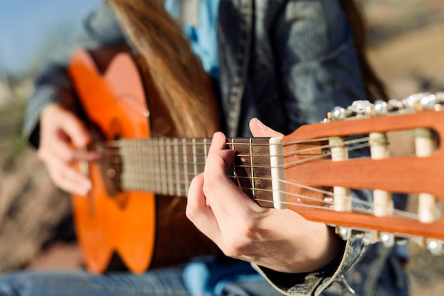 Frau spielt Gitarre an der Küste