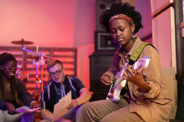 Frau spielt Gitarre bei einer lokalen Veranstaltung