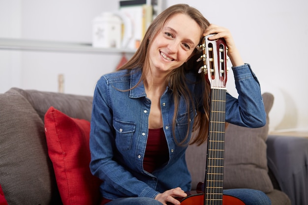 Frau spielt Gitarre zu Hause