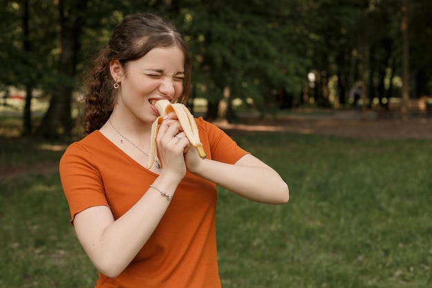 Frau spielt mit Banane im Park