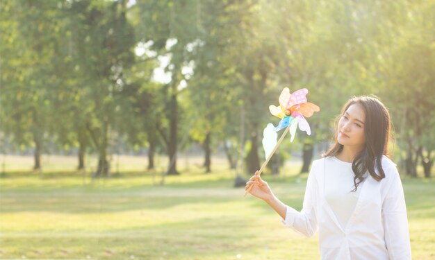 Frau spielt mit Blume im öffentlichen Park