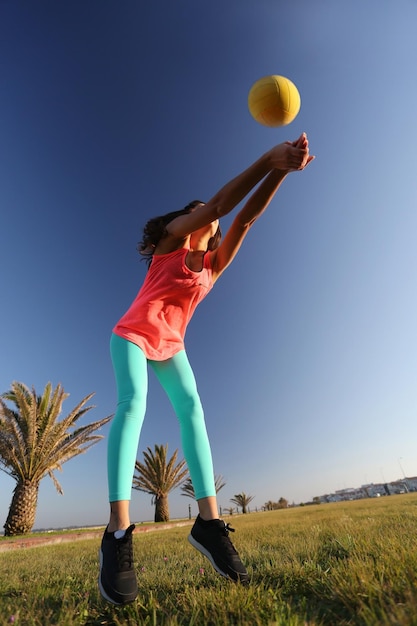 Foto frau spielt mit einem ball im stadtpark