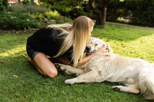 Frau spielt mit Hund Labrador im Freien