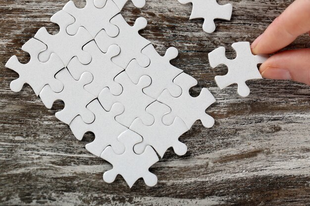 Foto frau spielt mit puzzle auf holztisch