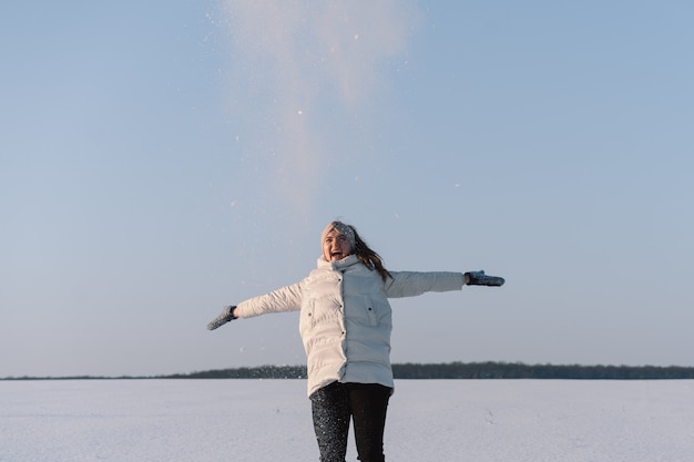 Frau spielt mit Schnee