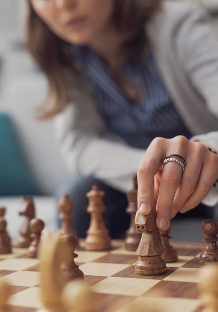 Foto frau spielt schach und bewegt eine figur