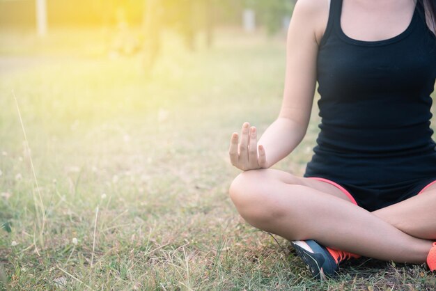 Frau spielt Yoga im Park