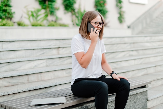 Frau spricht am Telefon draußen