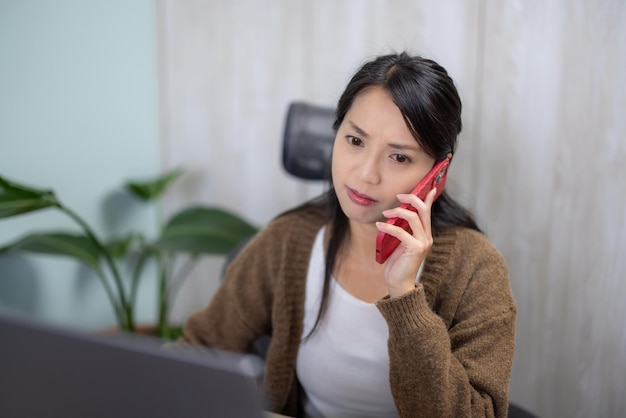 Frau spricht im Büro am Handy