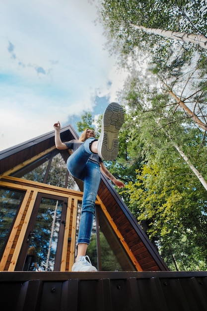 Frau springt von der Veranda der Blockhütte