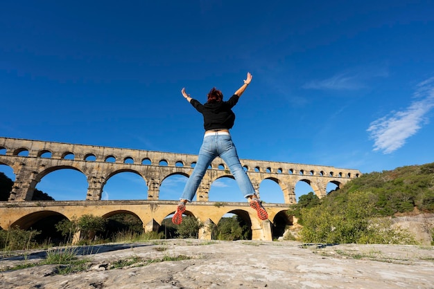 Frau springt vor Pont du Gard Frankreich