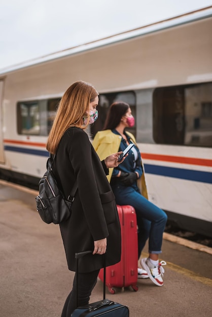 Frau steht am Bahnhof neben dem Zug