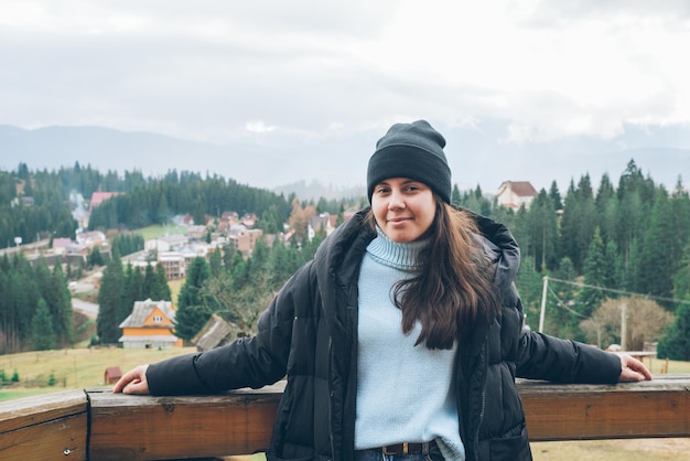 Frau steht am Balkon mit schöner Aussicht auf die Karpaten im Hintergrund. Platz kopieren