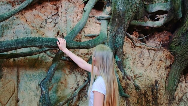 Foto frau steht am baumstamm