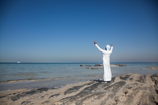 Foto frau steht am strand vor klarem himmel