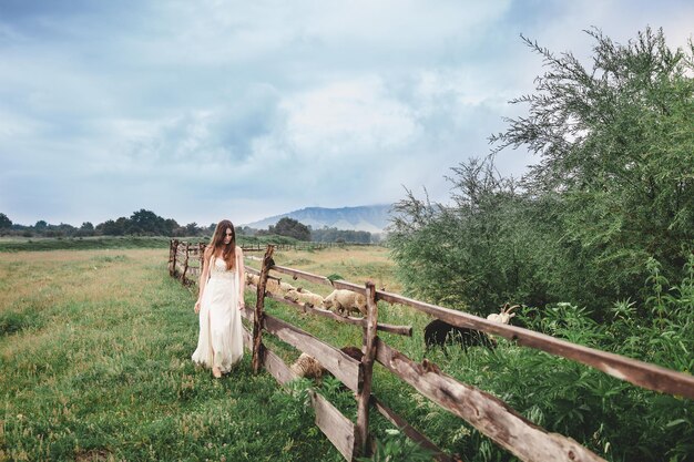 Foto frau steht auf dem feld gegen den himmel