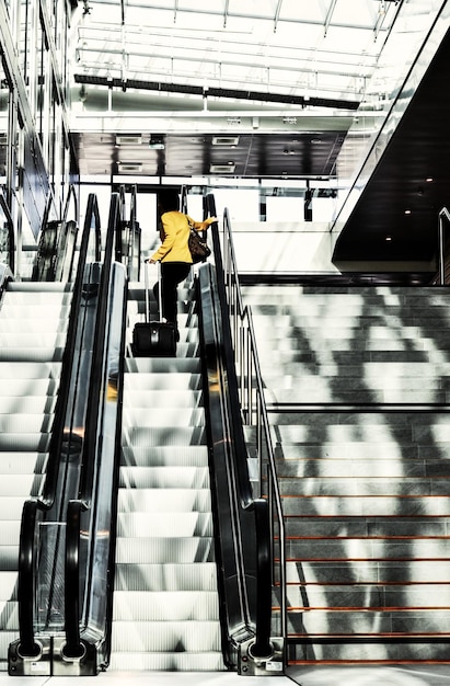 Frau steht auf der Rolltreppe