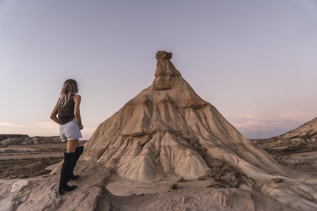 Frau steht auf einer Klippe in der Wüste von Las Bardenas Reales, Spanien