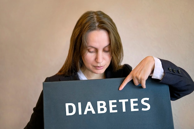 Foto frau steht auf und zeigt mit dem finger auf die inschrift an der tafel diabetes